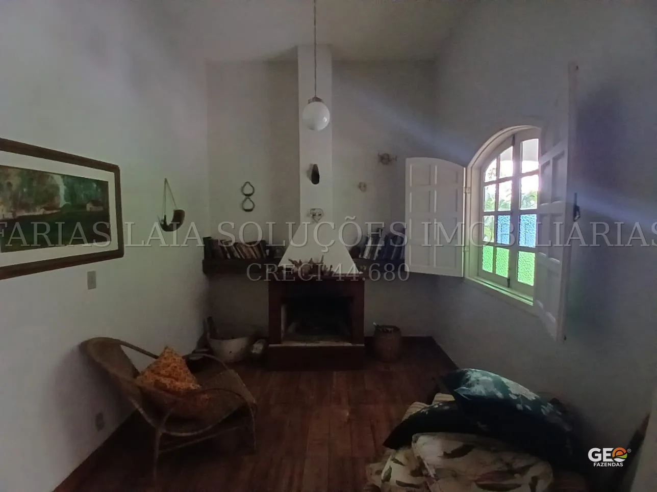 Sala rústica com lareira e janela colorida