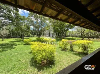 Área externa com jardim e árvores em propriedade rural
