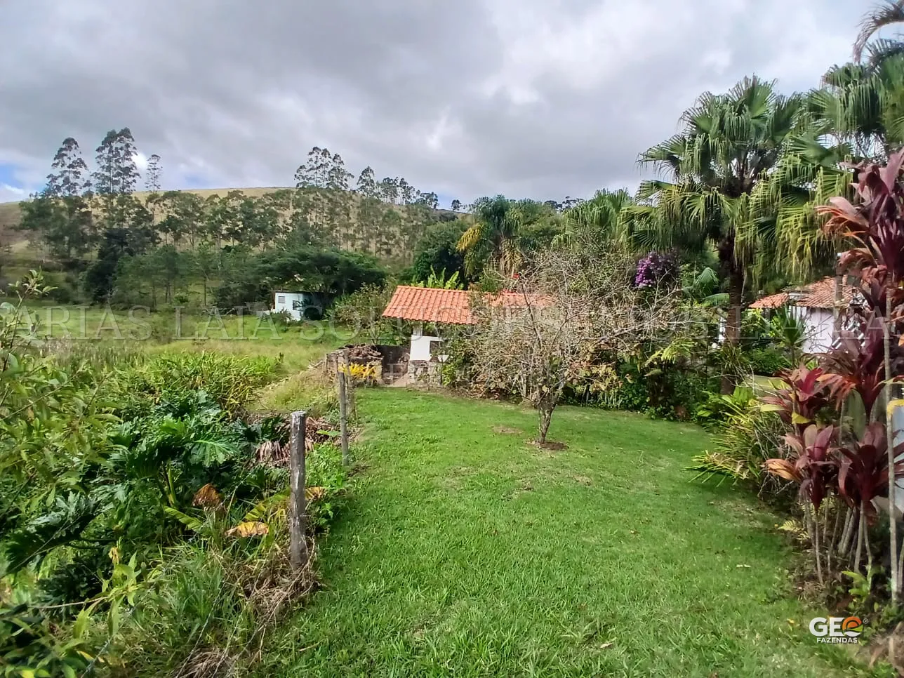 Casa rural com jardim e vegetação ao redor