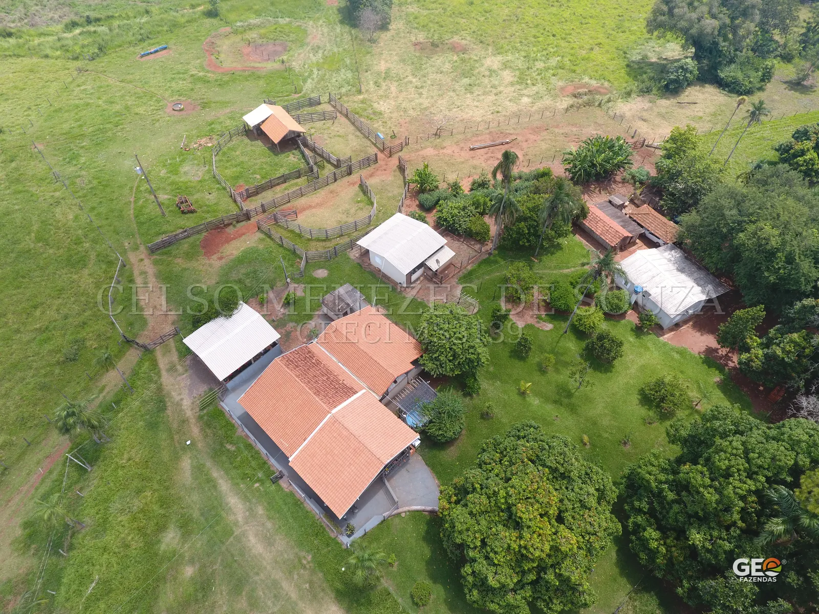 Vista aérea de propriedade rural com casas e cercados