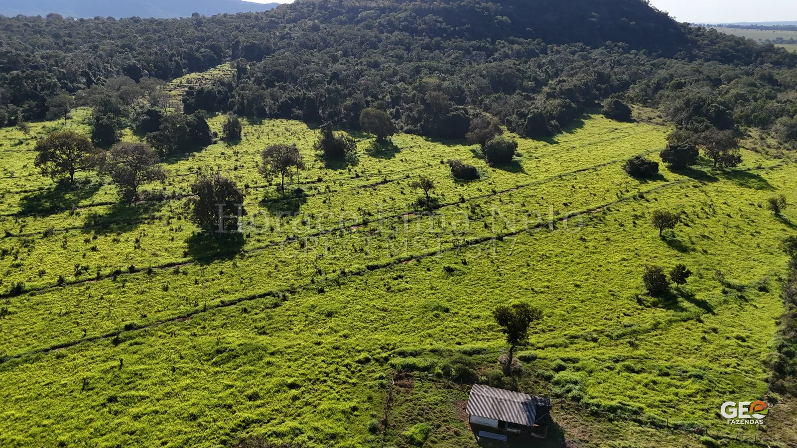 Área rural com pastagem e construção simples