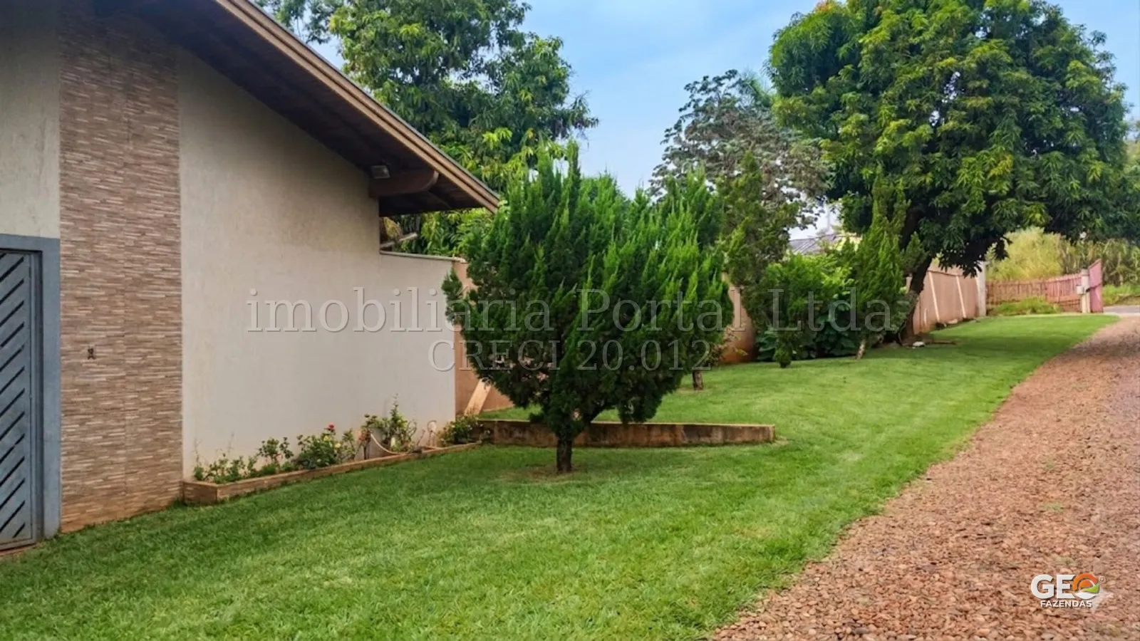Área externa com jardim e árvores em propriedade rural