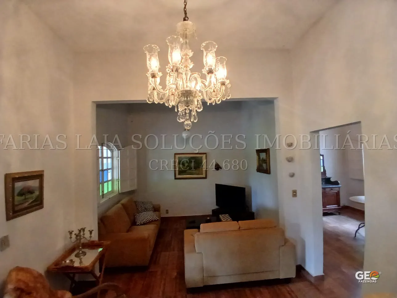 Sala de estar em casa de fazenda com lustre clássico