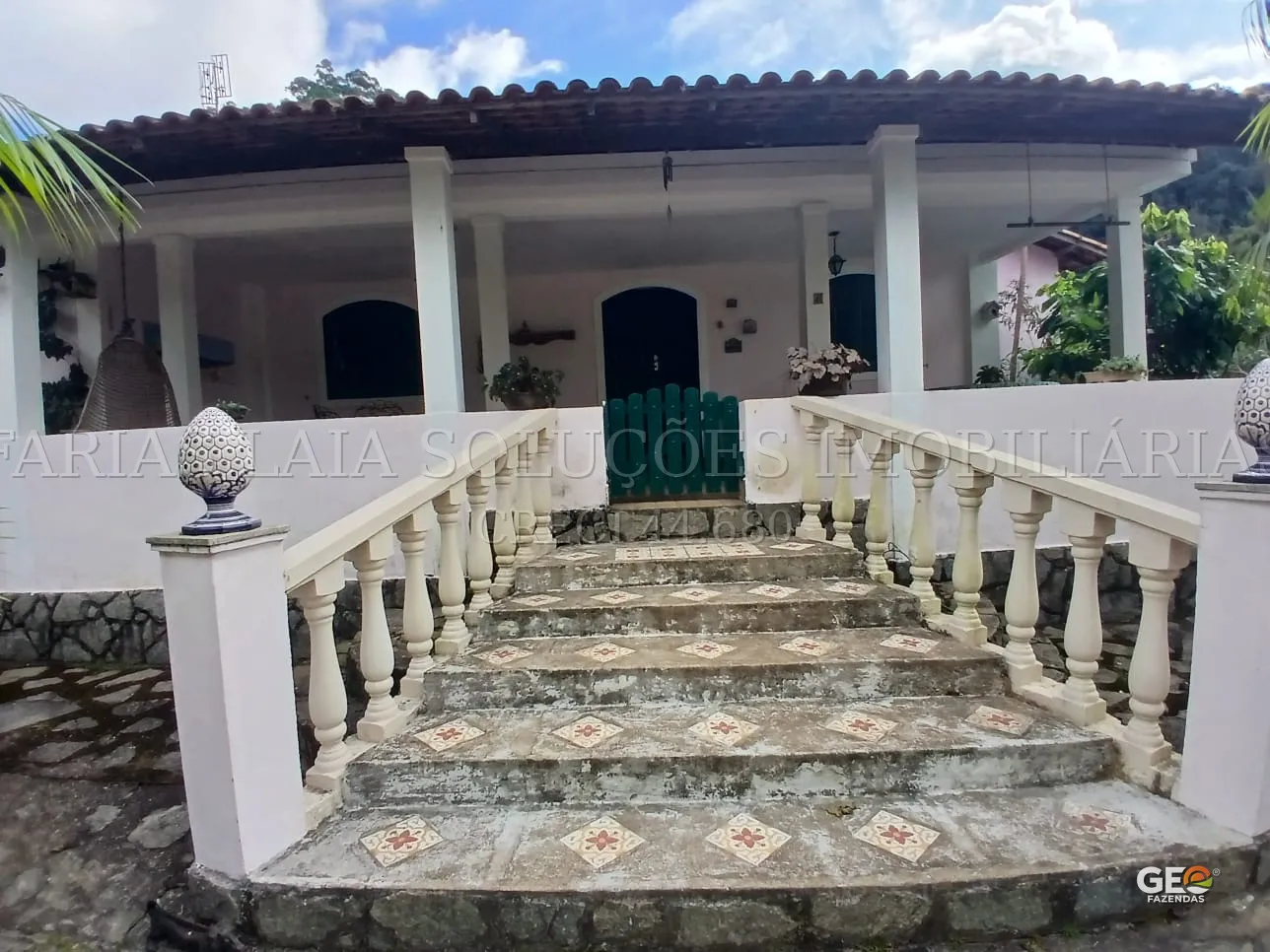 Entrada da casa com escadaria e varanda ampla