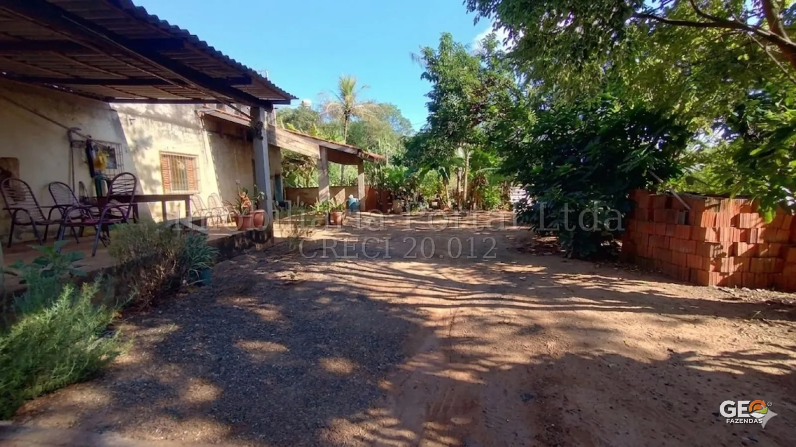 Área externa com casa e vegetação em propriedade rural