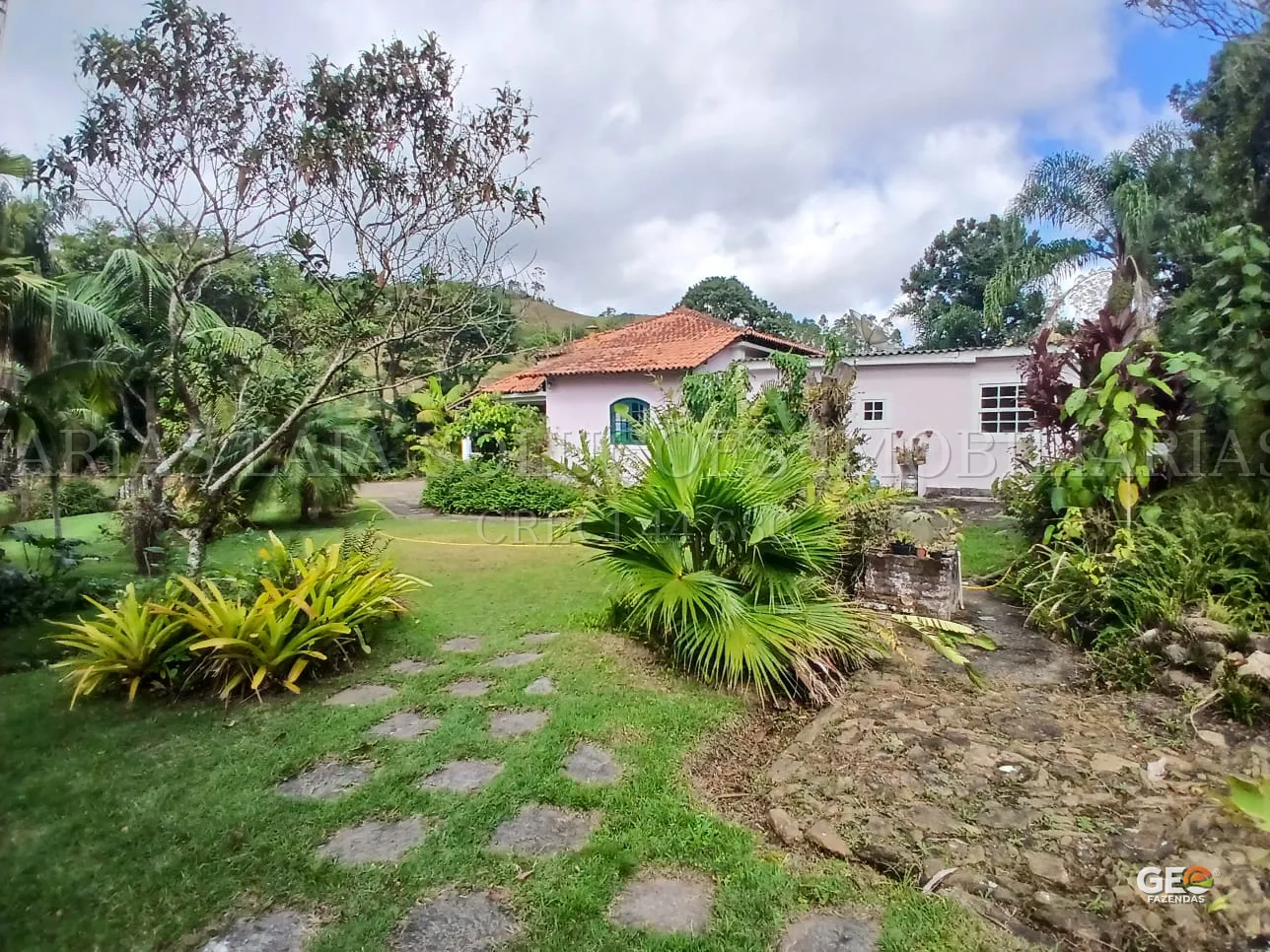 Casa rural com jardim e vegetação abundante