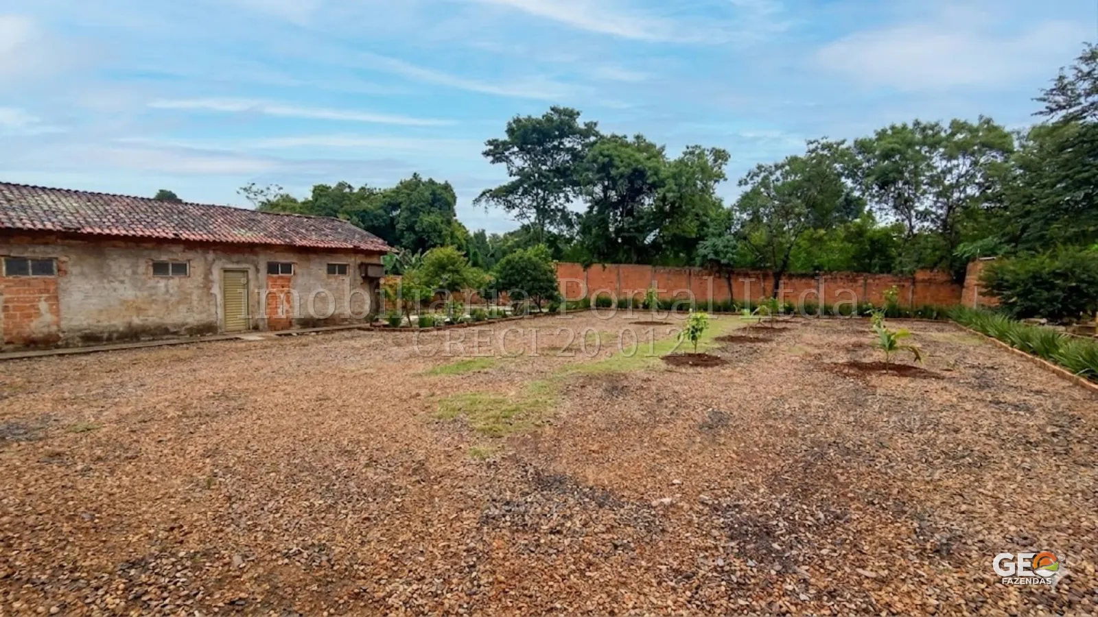 Área aberta com construção rústica e vegetação